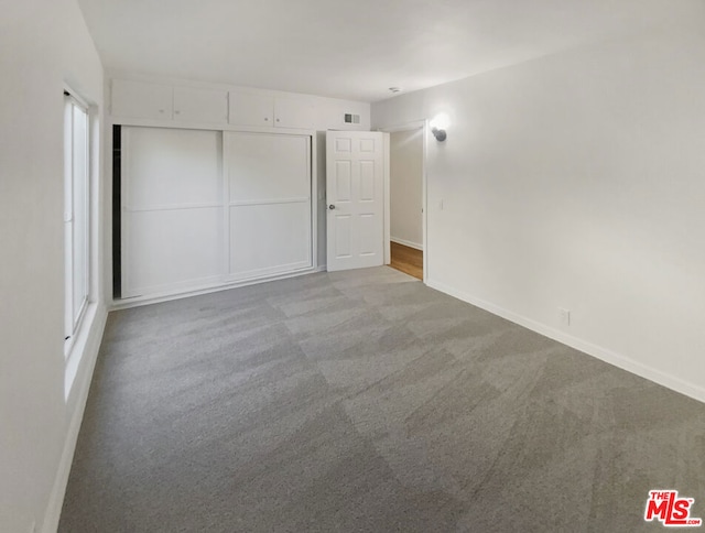 unfurnished bedroom with a closet and light carpet