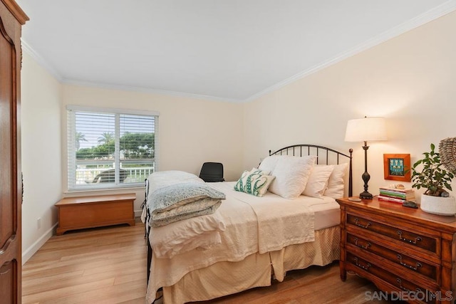 bedroom with light wood-type flooring and ornamental molding