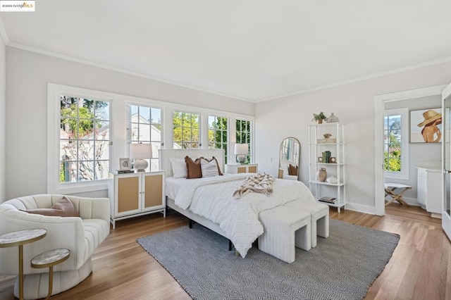 bedroom with ornamental molding, multiple windows, and light hardwood / wood-style flooring