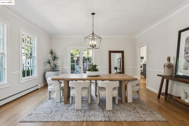 dining room featuring baseboard heating, ornamental molding, light hardwood / wood-style flooring, and plenty of natural light