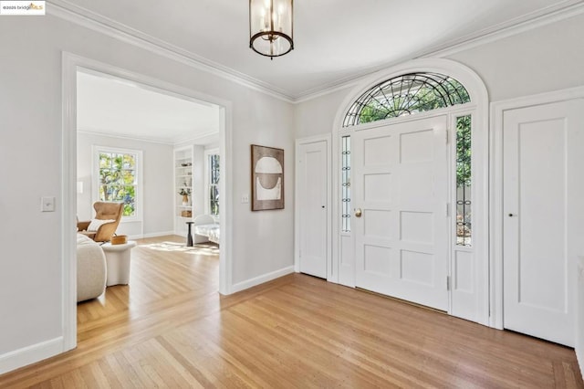 foyer featuring wood-type flooring, a notable chandelier, and ornamental molding