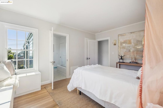 bedroom featuring ensuite bathroom and light hardwood / wood-style floors