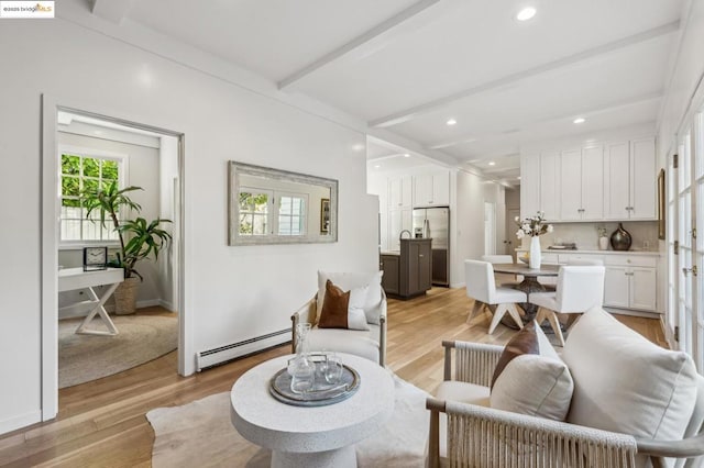 living room featuring a baseboard heating unit, light wood-type flooring, and beamed ceiling