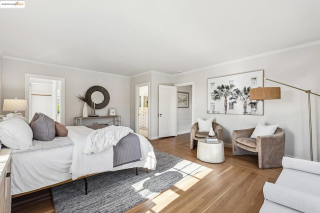 bedroom featuring wood-type flooring, ornamental molding, and ensuite bath