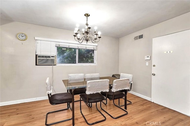 dining area with cooling unit, light hardwood / wood-style flooring, and a chandelier