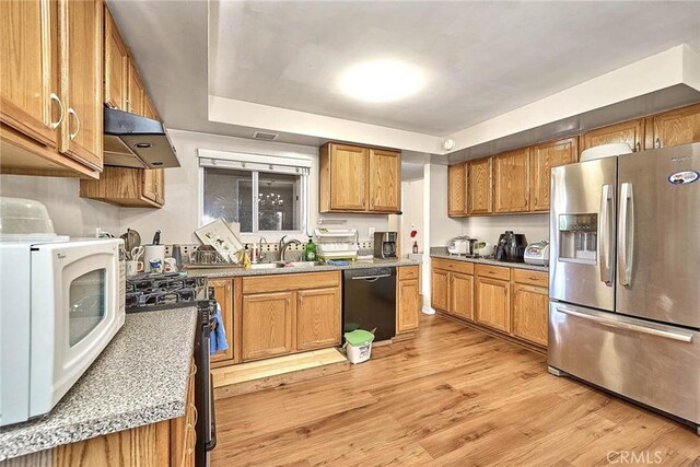 kitchen with stainless steel appliances, light wood-type flooring, range hood, and sink