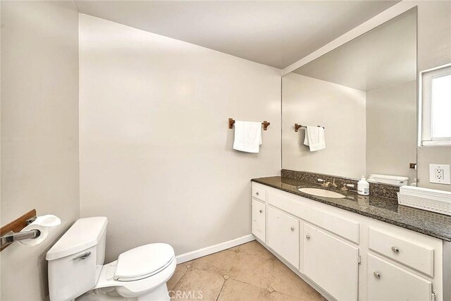 bathroom featuring toilet, vanity, and tile patterned floors