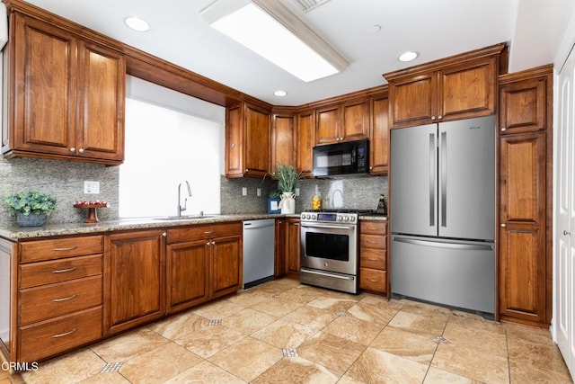 kitchen featuring appliances with stainless steel finishes, light stone countertops, light tile patterned floors, sink, and tasteful backsplash