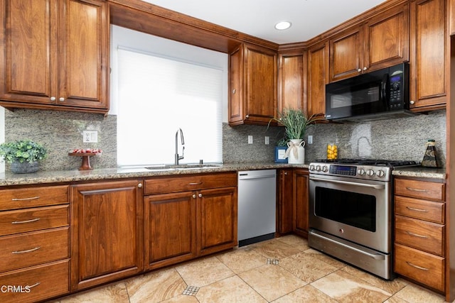 kitchen featuring sink, light stone counters, tasteful backsplash, white dishwasher, and gas stove