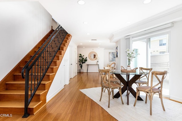 dining space featuring light hardwood / wood-style flooring and crown molding