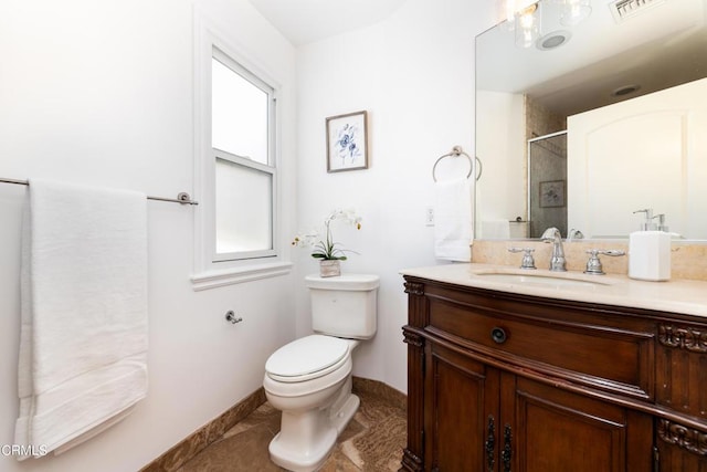 bathroom featuring toilet, tile patterned flooring, walk in shower, and vanity