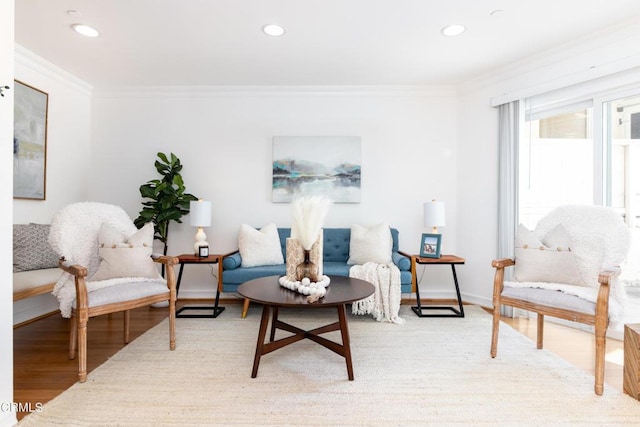 sitting room with ornamental molding and light hardwood / wood-style flooring