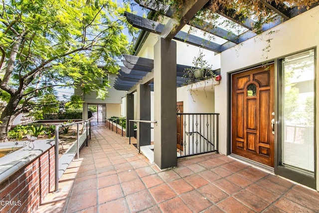 doorway to property with a pergola and a patio