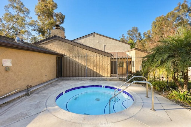 view of pool featuring fence, a gate, and a hot tub