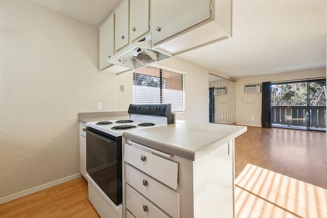 kitchen featuring white electric stove, light countertops, light wood-style floors, a wall mounted air conditioner, and under cabinet range hood