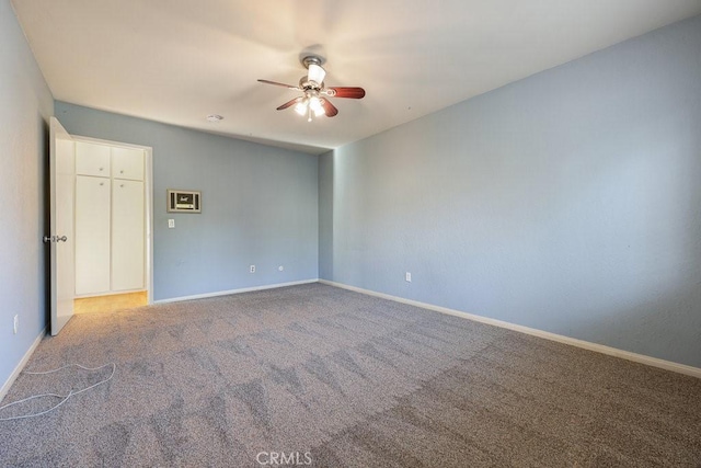 unfurnished room with carpet, a ceiling fan, and baseboards