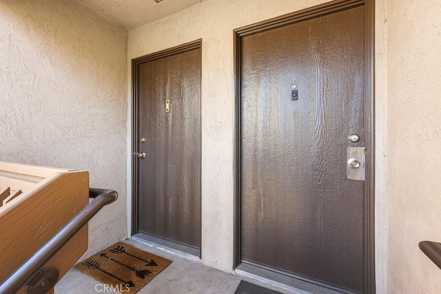 entrance to property featuring a balcony and stucco siding