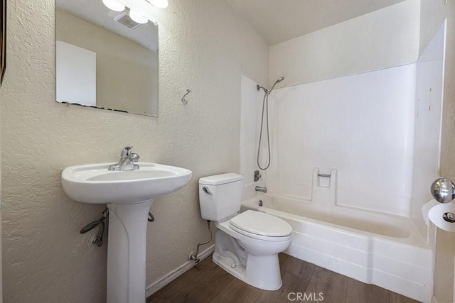 full bathroom featuring shower / bathtub combination, a textured wall, toilet, wood finished floors, and visible vents