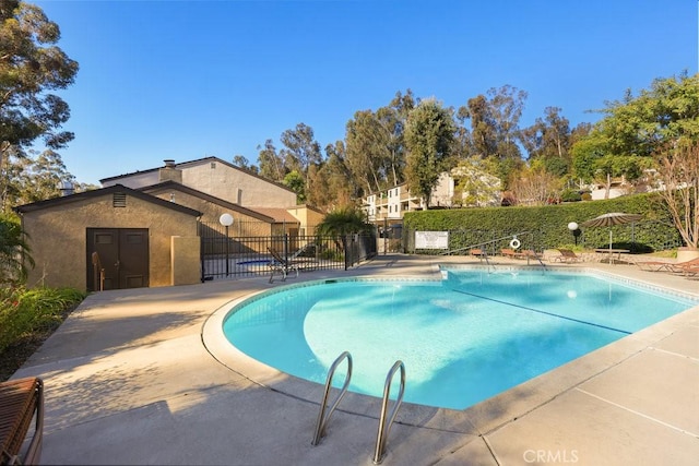 community pool featuring a patio and fence