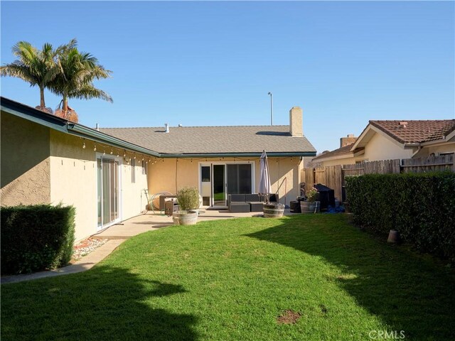 back of property with a patio area, a yard, and an outdoor hangout area