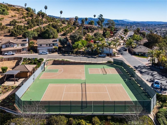 exterior space with community basketball court, fence, a mountain view, and a residential view