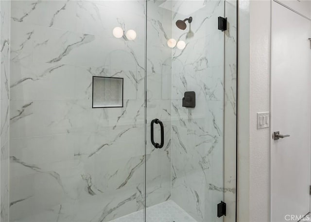 bathroom featuring a marble finish shower