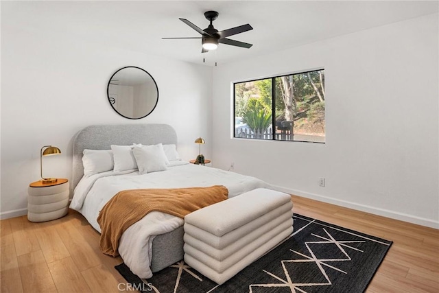 bedroom with ceiling fan, baseboards, and wood finished floors