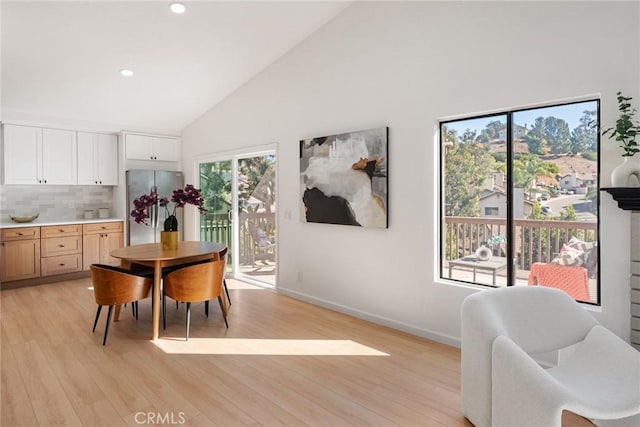 dining area featuring high vaulted ceiling, recessed lighting, baseboards, and light wood-style floors