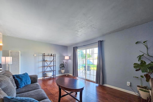 living room with a textured ceiling and dark wood-type flooring