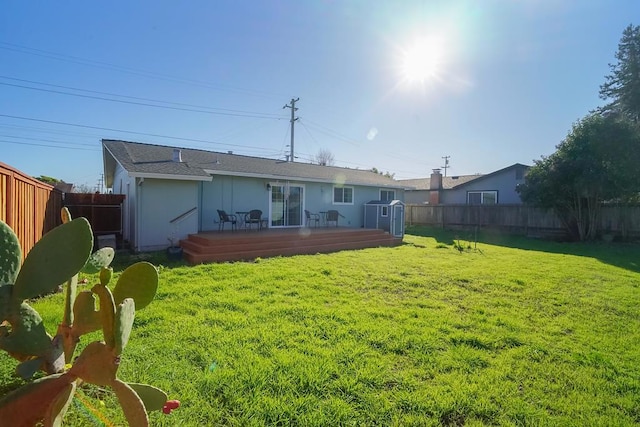 rear view of property with a yard and a deck