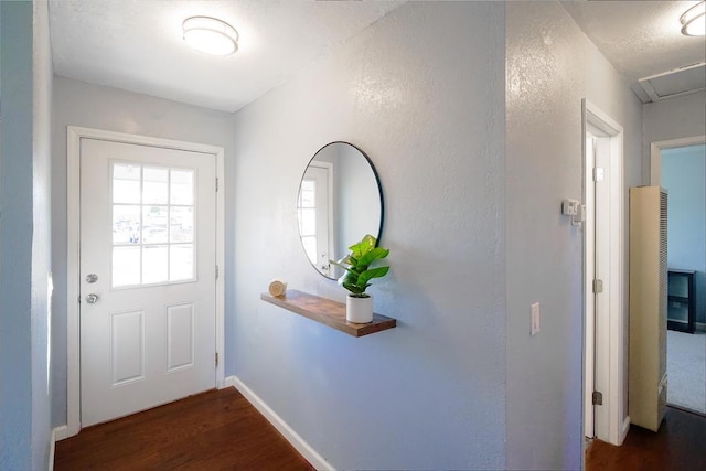 doorway to outside featuring dark wood-type flooring and a textured ceiling