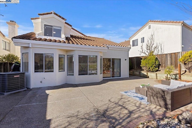 back of house with cooling unit, an outdoor living space, and a patio