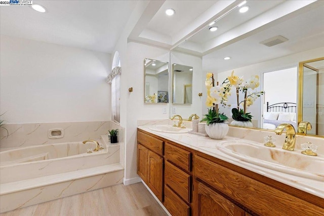 bathroom with a bathtub, vanity, and hardwood / wood-style flooring