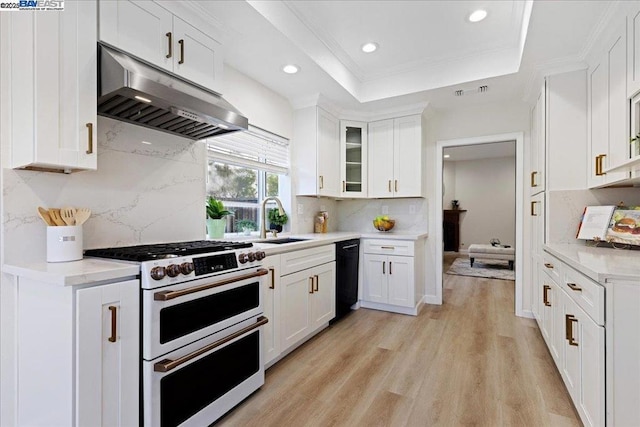 kitchen featuring white cabinets, double oven range, sink, and tasteful backsplash