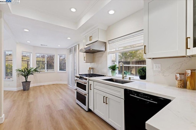 kitchen featuring light stone counters, double oven range, white cabinets, black dishwasher, and sink