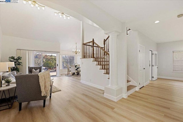 interior space with a notable chandelier, ornate columns, and wood-type flooring