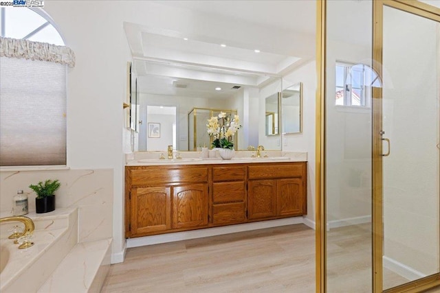 bathroom featuring hardwood / wood-style flooring, independent shower and bath, and vanity