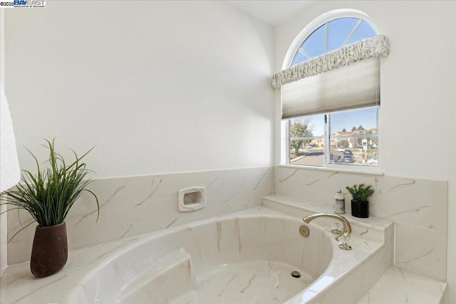 bathroom with a relaxing tiled tub