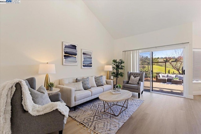 living room featuring high vaulted ceiling and wood-type flooring