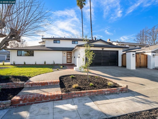 view of front of house featuring a garage and a front lawn