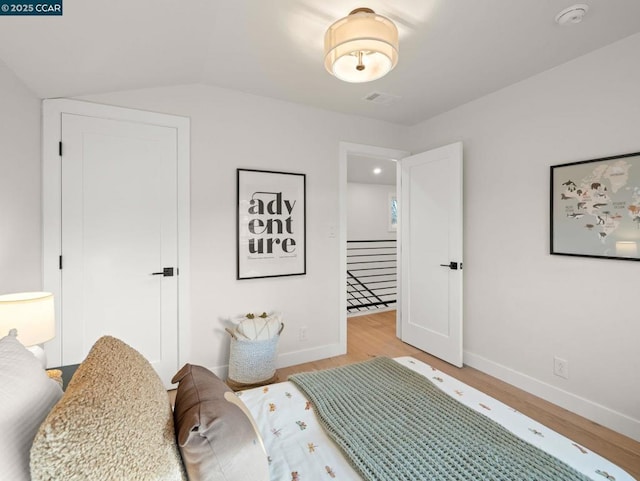 bedroom with light hardwood / wood-style flooring and vaulted ceiling