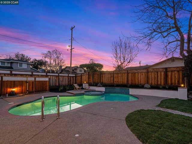 pool at dusk featuring a patio and an in ground hot tub