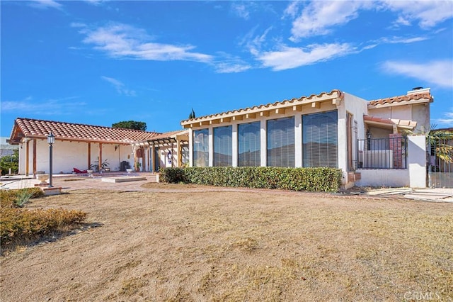 rear view of property with a patio and a lawn