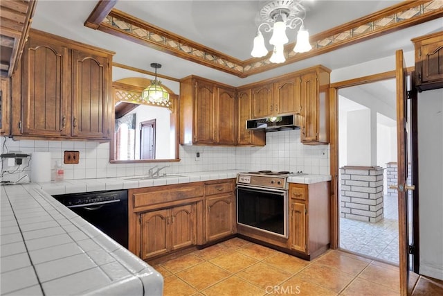 kitchen with hanging light fixtures, stainless steel range, crown molding, tile countertops, and tasteful backsplash