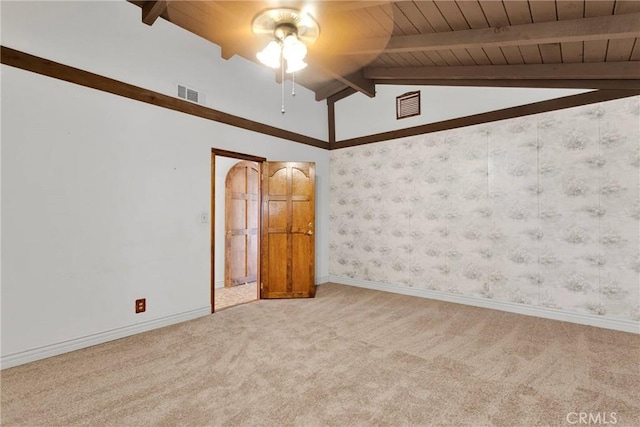 carpeted spare room featuring ceiling fan and vaulted ceiling with beams