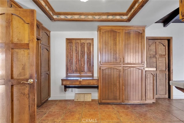 interior space with ornamental molding and light tile patterned floors