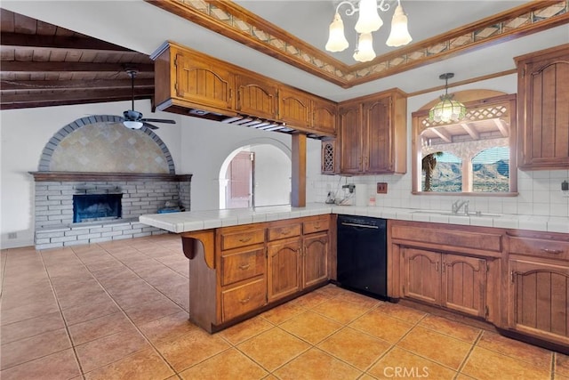 kitchen featuring hanging light fixtures, dishwasher, decorative backsplash, and tile counters