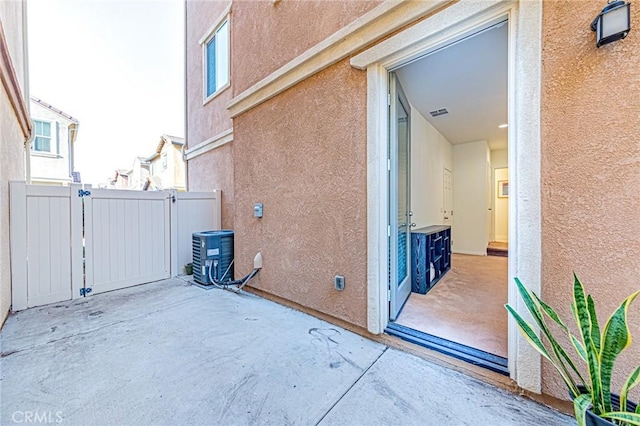 view of side of property with a patio area and central AC unit