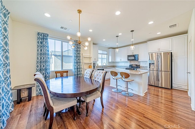 dining area with a healthy amount of sunlight, light hardwood / wood-style floors, and sink