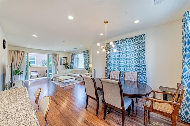 dining space featuring a notable chandelier and wood-type flooring